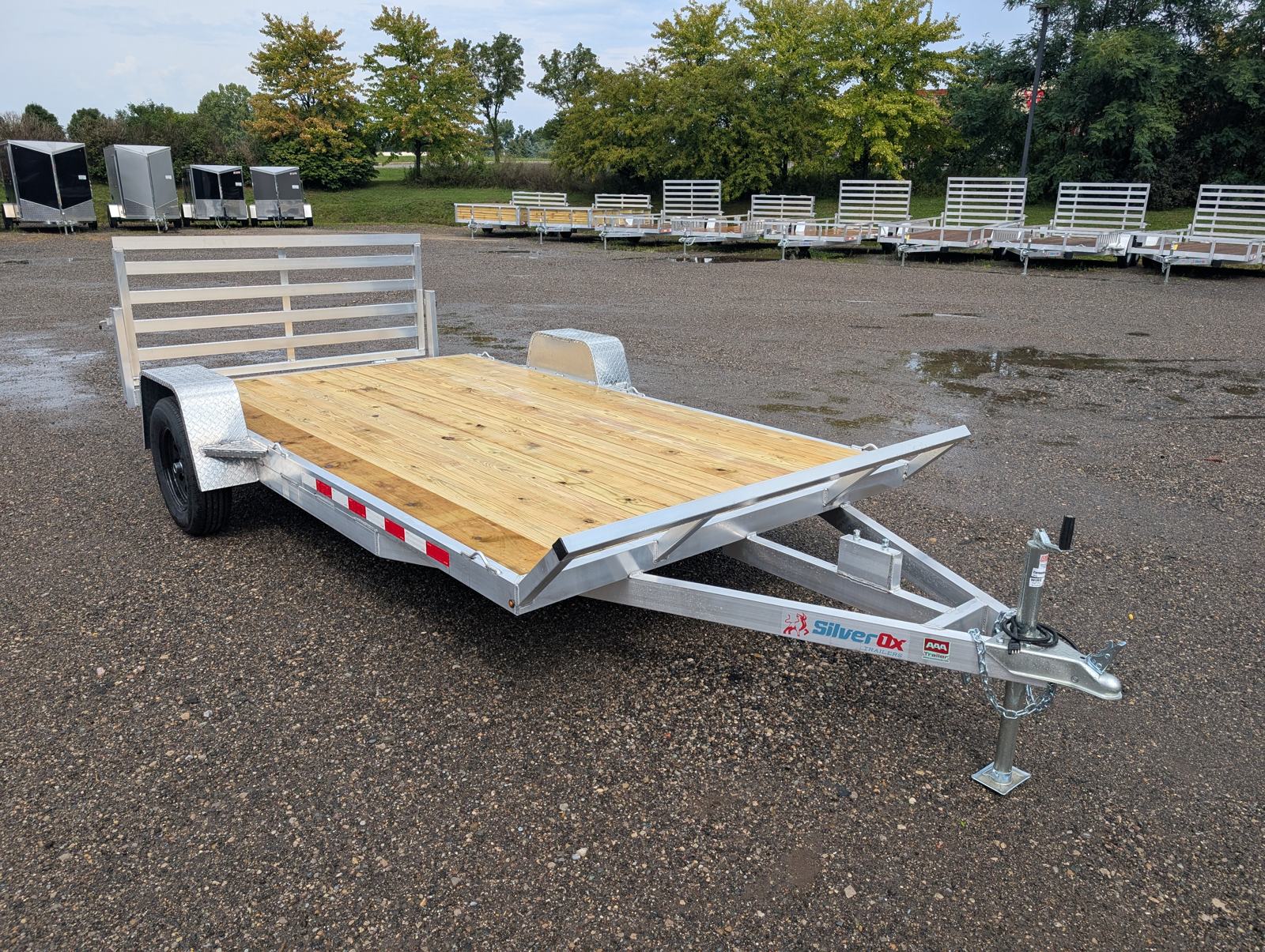 Rear three-quarter view of the Silver Ox 7x14 Oxtail Sport with the gate up, showing the dovetail deck transition, aluminum fender, and wheel